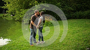 Outdoors portrait of the lovely couple kissing at the city park. Woman and man in love outside.