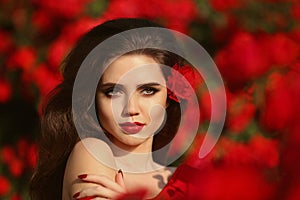 Outdoors portrait of Natural Beauty woman in red roses. Sensual
