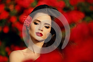 Outdoors portrait of Natural Beauty woman in red roses. Sensual