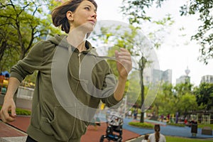 Outdoors portrait of young attractive and active  jogger woman in hoodie top  running and jogging in morning workout at beautiful