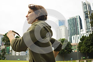 Outdoors portrait of young attractive and active  jogger woman in hoodie top  running and jogging in morning workout at beautiful