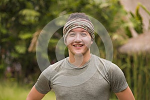 Outdoors portrait of young attractive and happy hipster man enjoying tropical nature exploring exotic Asian tourist destination