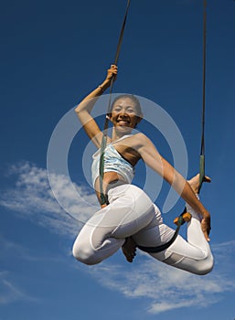 Outdoors portrait of young happy and athletic Asian Indonesian woman doing aero yoga workout training body balance and relaxation