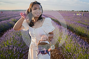 Outdoors romantic portrait of young happy and attractive woman in white summer dress enjoying carefree at beautiful lavender