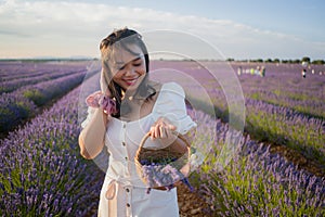 Outdoors romantic portrait of young happy and attractive woman in white summer dress enjoying carefree at beautiful lavender