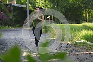 Outdoors running workout - young happy and dedicated Asian Chinese woman jogging at beautiful city park or countryside trail on