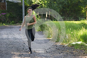 Outdoors running workout - young happy and dedicated Asian Korean woman jogging at beautiful city park or countryside trail on