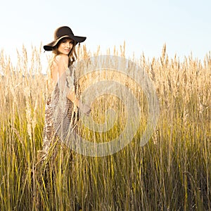 Outdoors sunrise shot of beautiful young model in tallgrass meadow photo