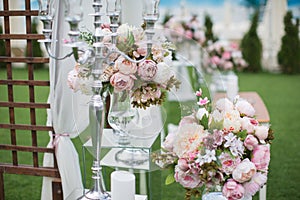 Outdoors wedding decoration with flower bouquets, candles and ga