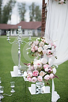 Outdoors wedding decoration with flower bouquets, candles and ga