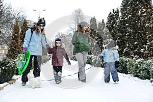 Outdoors winter activities for family, friends. Happy Family, friends, two women, two boy kids and dog, mothers and sons