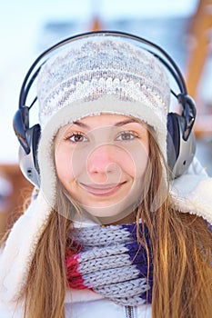 Outdoors on a winter day. Woman listening music.