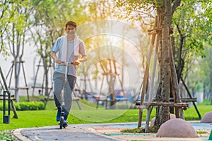 Outdoors workout and exercise background of man ridding on kick scooter on pavement in park