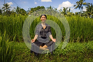 Outdoors yoga and meditation at rice field - attractive and happy middle aged Asian Chinese woman enjoying yoga and relaxation in