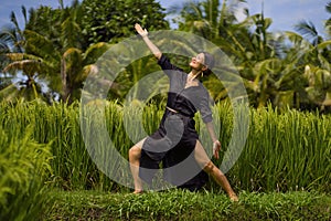 Outdoors yoga and meditation at rice field - attractive and happy middle aged Asian Chinese woman enjoying yoga and relaxation in