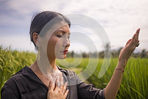 Outdoors yoga and meditation at rice field - attractive and happy middle aged Asian Chinese woman enjoying yoga and relaxation in