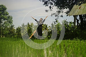 Outdoors yoga and meditation at rice field - attractive and happy middle aged Asian Japanese woman enjoying yoga and relaxation in