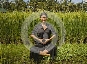 Outdoors yoga and meditation at rice field - attractive and happy middle aged Asian Japanese woman enjoying yoga and relaxation in