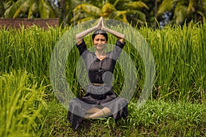 Outdoors yoga and meditation at rice field - attractive and happy middle aged Asian Japanese woman enjoying yoga and relaxation in