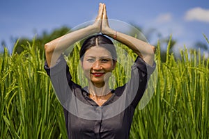 Outdoors yoga and meditation at rice field - attractive and happy middle aged Asian Japanese woman enjoying yoga and relaxation in