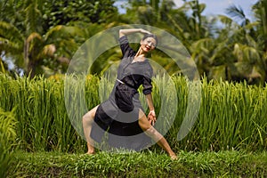 Outdoors yoga and meditation at rice field - attractive and happy middle aged Asian Japanese woman enjoying yoga and relaxation in