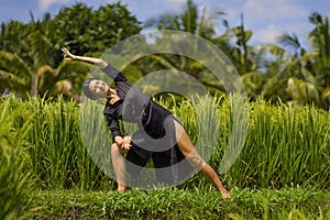 Outdoors yoga and meditation at rice field - attractive and happy middle aged Asian Korean woman enjoying yoga and relaxation in