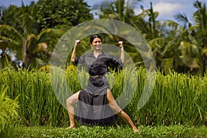 Outdoors yoga and meditation at rice field - attractive and happy middle aged Asian Korean woman enjoying yoga and relaxation in