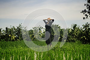 Outdoors yoga and meditation at rice field - attractive and happy middle aged Asian Korean woman enjoying yoga and relaxation in