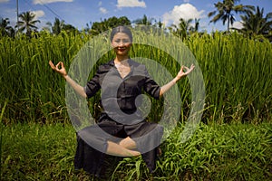 Outdoors yoga and meditation at rice field - attractive and happy middle aged Asian Korean woman enjoying yoga and relaxation in