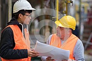 Young Asian apprentice at work with senior engineer
