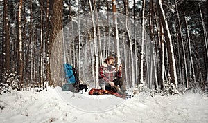 Outdoorsman drinking tea, winter forest