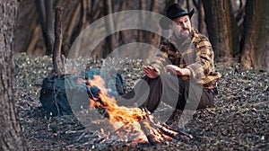 Outdoorsman warming hands from campfire photo