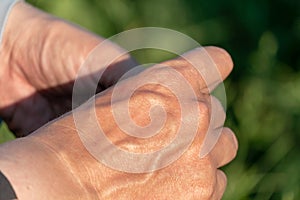 the outer side of the male palm. Muscles and veins of the arm close-up. Sweaty hand after a workout