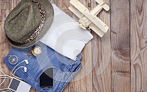 Outfit of traveler and accessories on wood background with copy