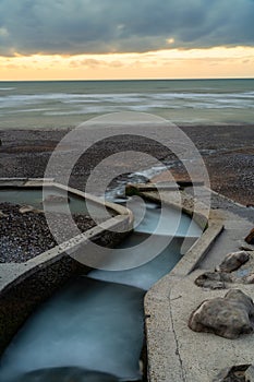 Outflow of the river Veules into the ocean at sunset