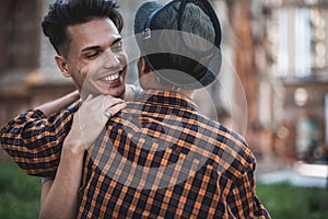 Outgoing man embracing friend during meeting outside