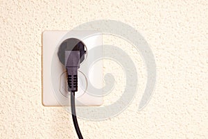 Outlet with plug against a textured backgrund