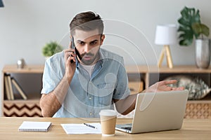 Outraged unhappy businessman talking on phone, unpleasant conversation