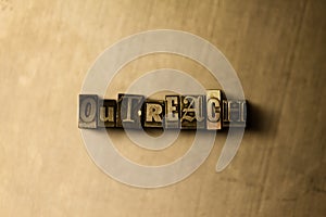 OUTREACH - close-up of grungy vintage typeset word on metal backdrop