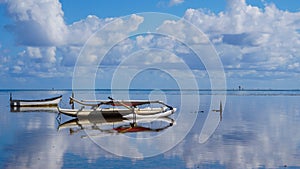 An Outrigger Canoe is Perfectly Mirrored in the Waters of Kaneohe Bay