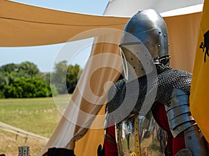 outside a camp tent of a medieval knight plate armor on a mannequin