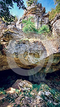 Outside of a cave in the mountain.