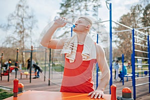 Outside Fitness A Tired Sportsman Rests and Rehydrates with Water.