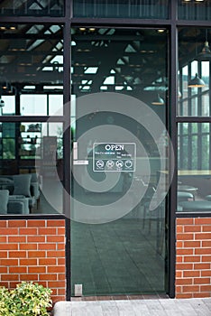 Outside glass door of modern cafe restaurant with Open sign