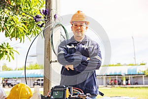 Outside, an ISP Internet Service Provider engineer stands near a fiber optic cross box photo