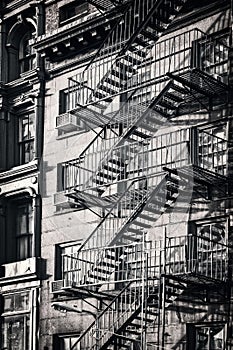 Outside metal fire escape stairs, New York City black and white