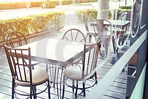 Outside shop in sunny day with tables and chairs of cafe , restaurant in the morning time which nobody uses them  .Outdoor of