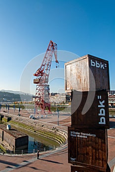 Outside view of the Maritine Museum of Bilbao, Spain with a red crane in the background