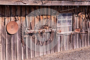 Outside wall of an old barn with old rusty instruments on it