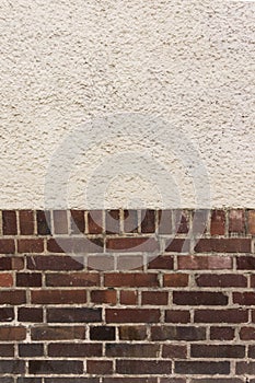 Outside wall with plastered top on red clinker brick bottom